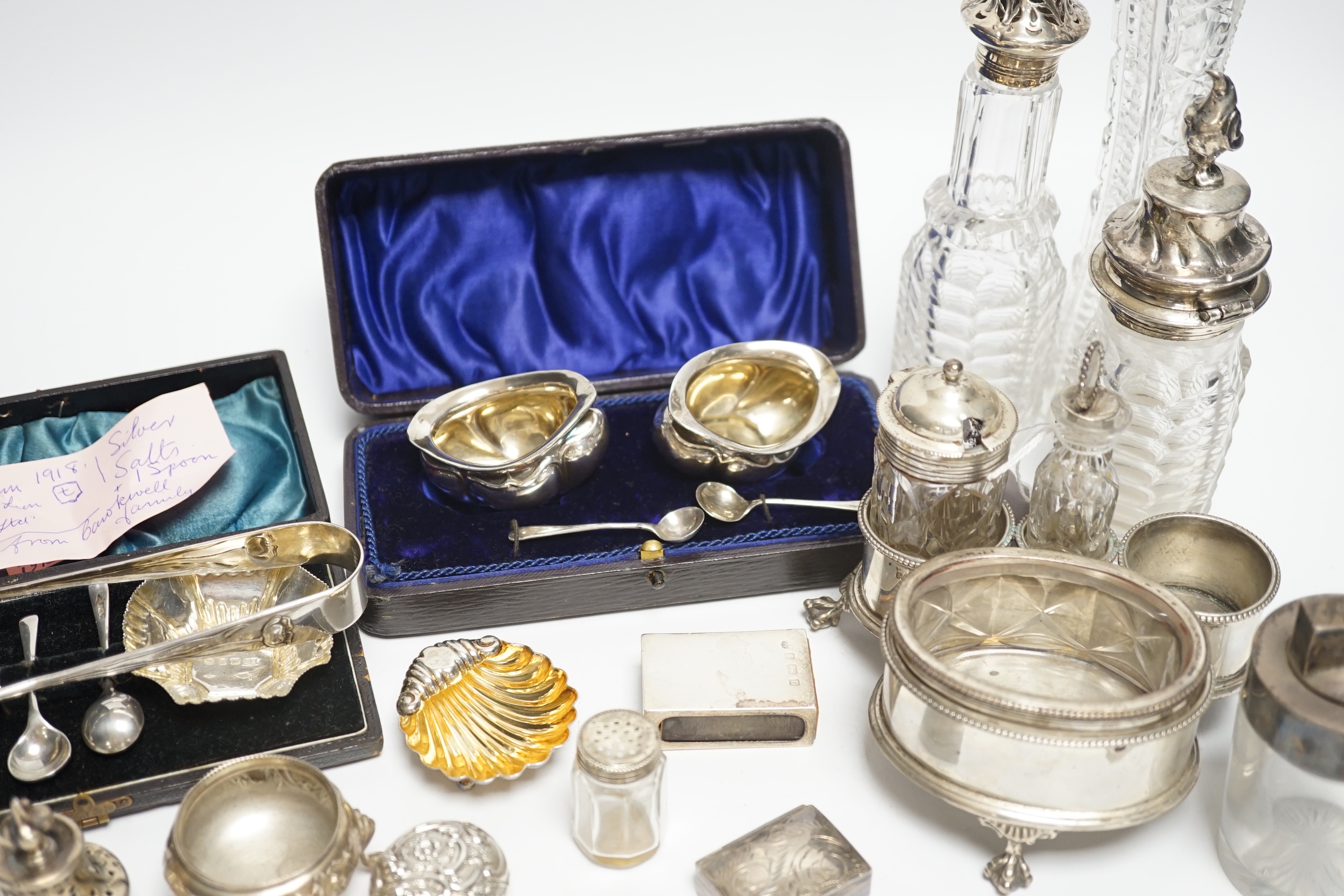 Sundry small silver including a Victorian silver cruet stand, London, 1858 (lacking one bottle), two salts, a vesta case, pill boxes, pair of sugar tongs, two cased pairs of salts with spoons, five mounted glass bottles,